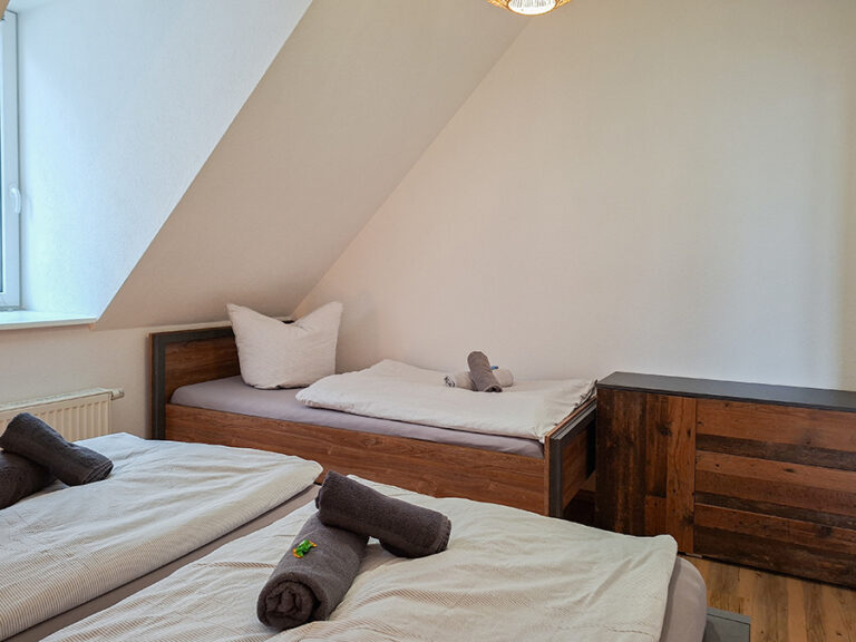 Schlafzimmer mit 1 x Doppelbett + 1 x Einzelbett - Wohnung 8