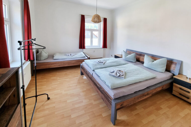 Schlafzimmer mit Doppelbett und Einzelbett - Wohnung 3