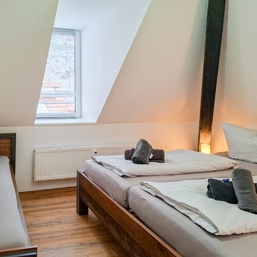 Schlafzimmer mit Doppelbett und Einzelbett - Wohnung 6