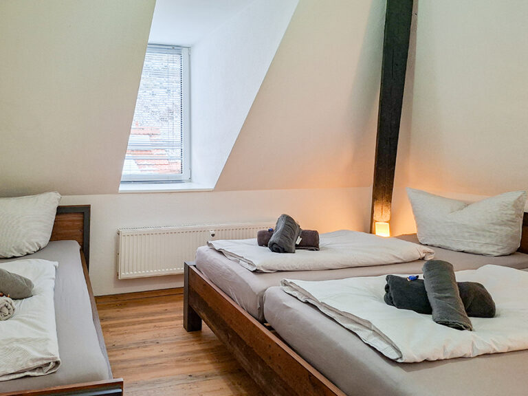 Schlafzimmer mit Doppelbett und Einzelbett - Wohnung 6