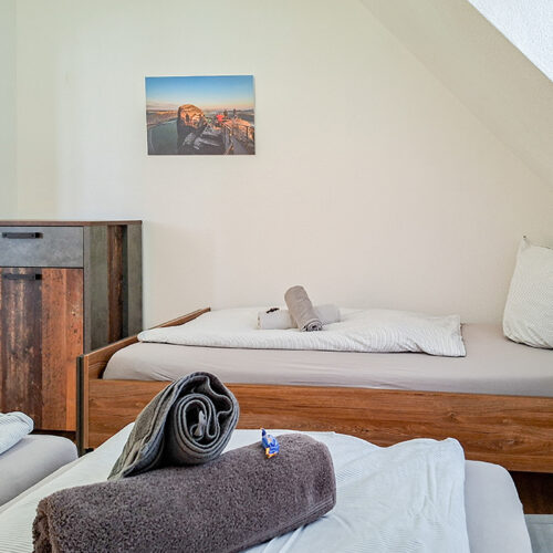 Schlafzimmer mit Doppelbett und Einzelbett - Wohnung 6
