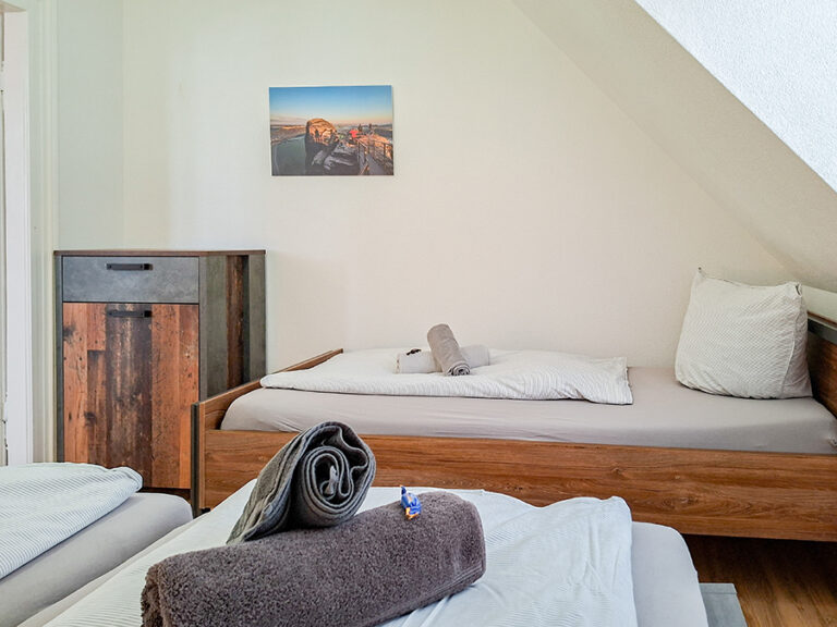 Schlafzimmer mit Doppelbett und Einzelbett - Wohnung 6