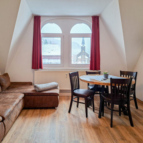 Wohnzimmer mit Couch und Esstisch - Wohnung 6