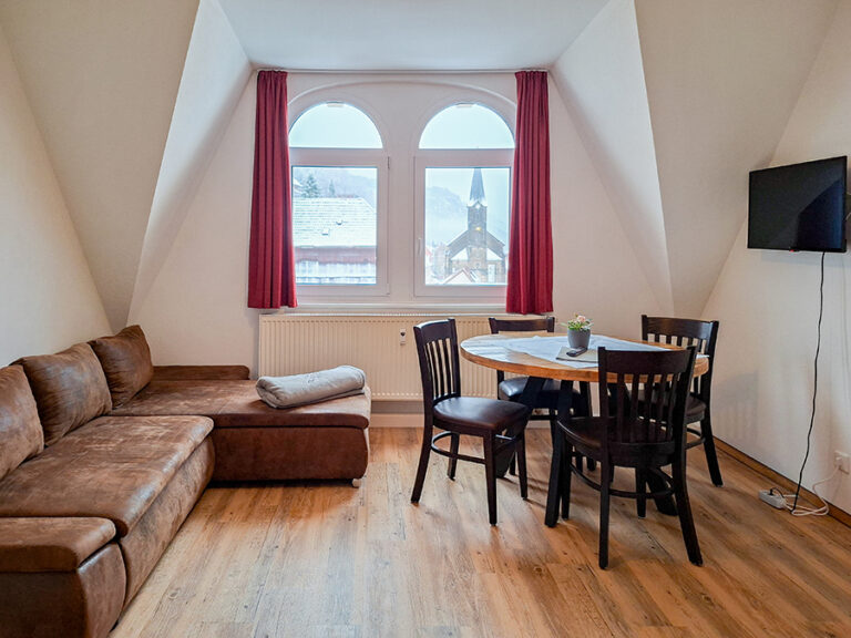 Wohnzimmer mit Couch und Esstisch - Wohnung 6