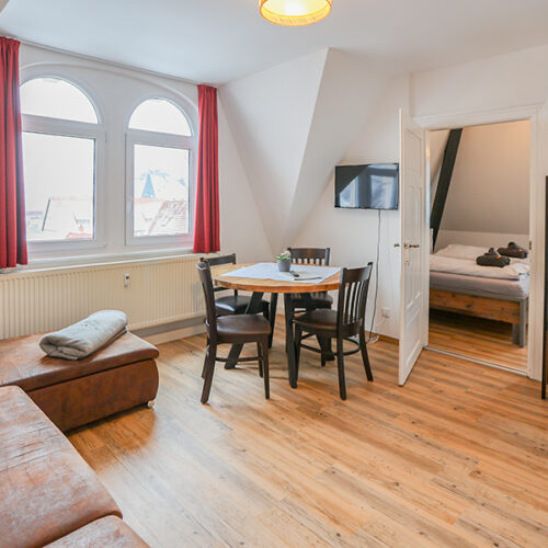 Wohnzimmer mit Couch und Esstisch - Wohnung 6