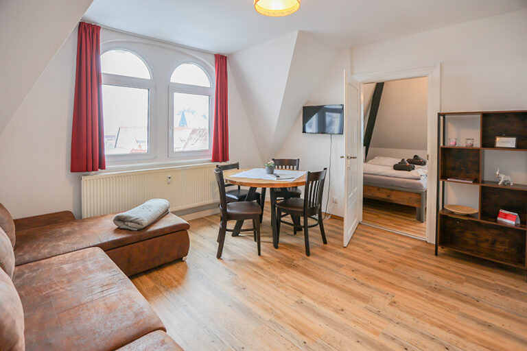 Wohnzimmer mit Couch und Esstisch - Wohnung 6